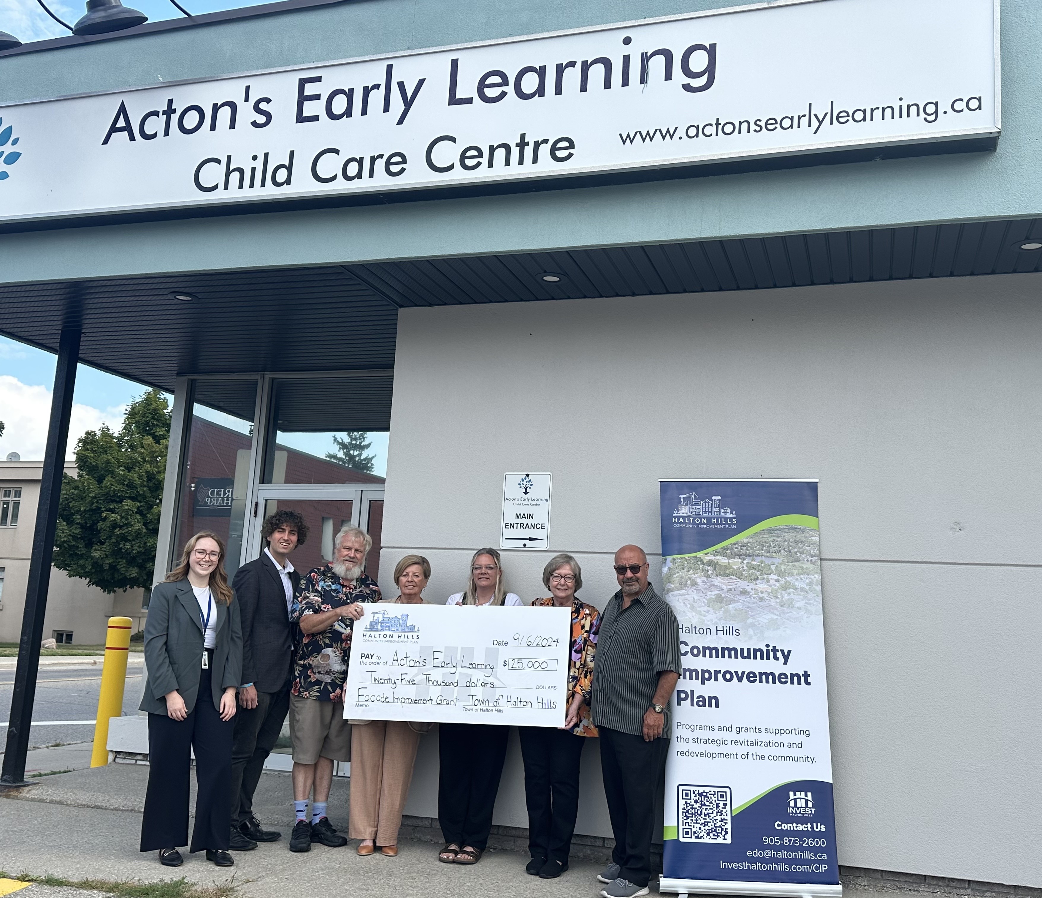 Town staff and elected officials holding large cheque for Acton Early Learning staff